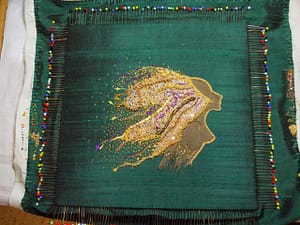 Preparations for mounting: pinning the embroidery on the cardboard